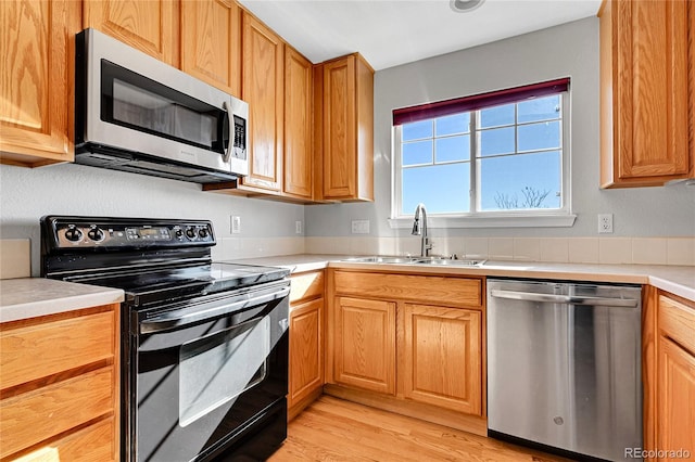 7511 S Sicily Way, Aurora, CO 80016 - kitchen featuring stainless steel appliances, a sink, light countertops, and light wood-style floors