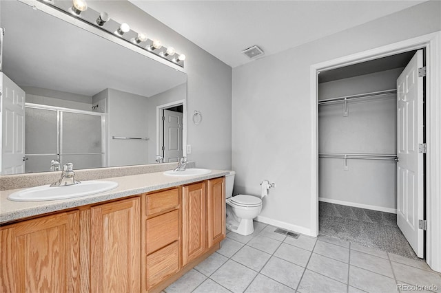 7511 S Sicily Way, Aurora, CO 80016 - bathroom with a shower stall, tile patterned flooring, double vanity, toilet, and a walk in closet