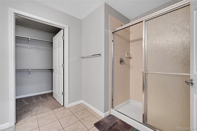 7511 S Sicily Way, Aurora, CO 80016 - full bathroom with a stall shower, tile patterned flooring, a walk in closet, and baseboards
