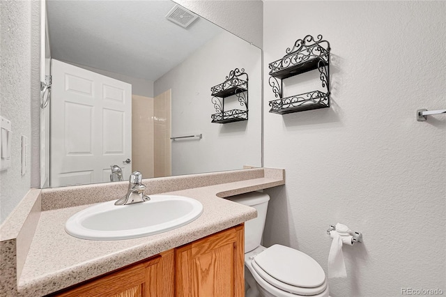 7511 S Sicily Way, Aurora, CO 80016 - bathroom with toilet, vanity, and a textured wall
