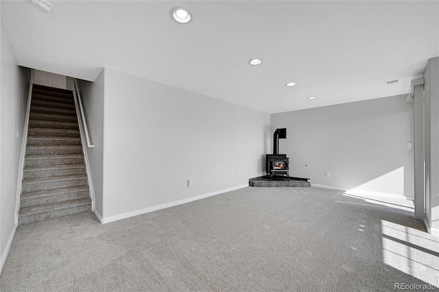7511 S Sicily Way, Aurora, CO 80016 - unfurnished living room featuring a wood stove, carpet flooring, stairway, recessed lighting, and baseboards