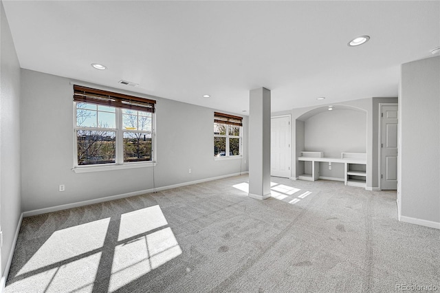 7511 S Sicily Way, Aurora, CO 80016 - unfurnished living room featuring light colored carpet, recessed lighting, baseboards, and arched walkways