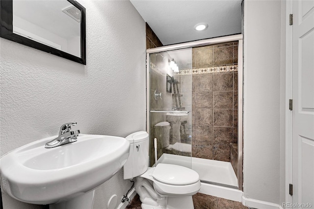 7511 S Sicily Way, Aurora, CO 80016 - full bathroom featuring toilet, a stall shower, a sink, and a textured wall