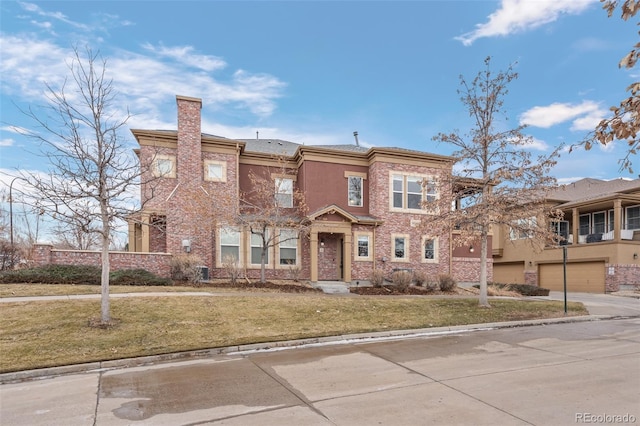 view of property featuring a garage and a front lawn