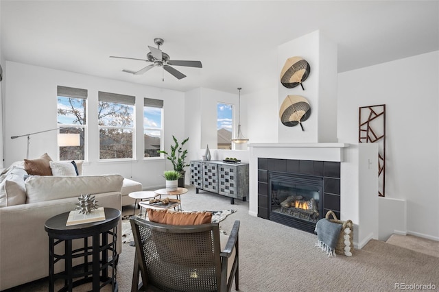 carpeted living room with a fireplace and ceiling fan