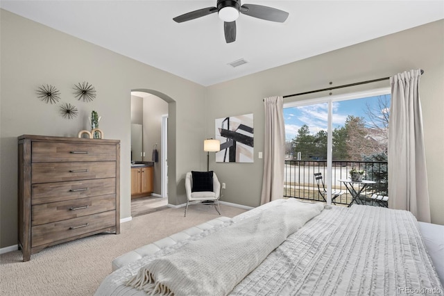 bedroom featuring ceiling fan, light carpet, access to exterior, and ensuite bathroom