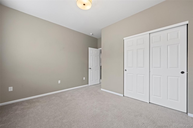 unfurnished bedroom featuring a closet and light colored carpet