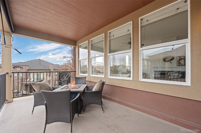 view of patio / terrace with an outdoor fire pit and a balcony