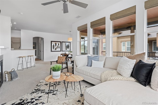 carpeted living room with ceiling fan