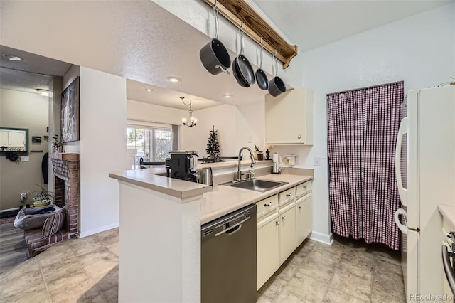 kitchen featuring dishwasher, sink, decorative light fixtures, white fridge, and kitchen peninsula