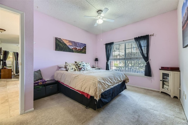 bedroom with light carpet, ceiling fan, and a textured ceiling