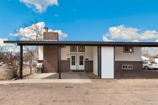 1512 E Monument St, Colorado Springs, CO 80909 - view of front of home featuring brick siding, a chimney, and french doors