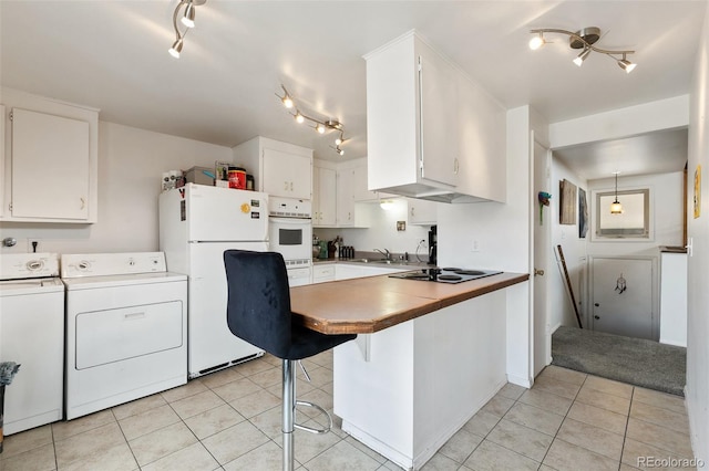 1512 E Monument St, Colorado Springs, CO 80909 - kitchen with white appliances, rail lighting, light tile patterned floors, washing machine and dryer, and a sink