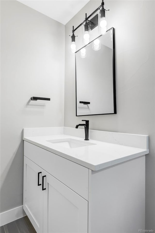 1541 Glencoe St, Denver, CO 80220 - bathroom with vanity, baseboards, and wood finished floors