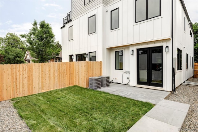 1541 Glencoe St, Denver, CO 80220 - back of property with board and batten siding, cooling unit, and a patio area
