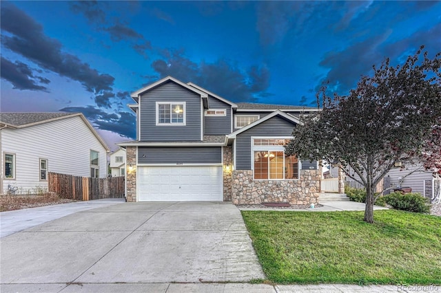 view of front facade with stone siding, concrete driveway, a front yard, and fence