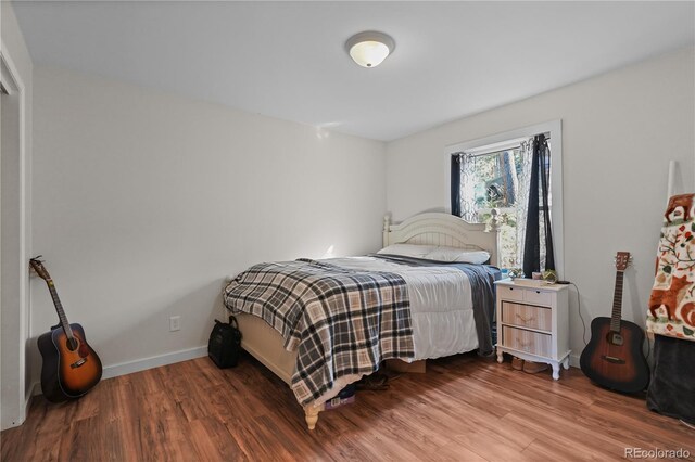 bedroom featuring baseboards and wood finished floors