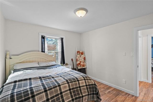 bedroom with baseboards and wood finished floors