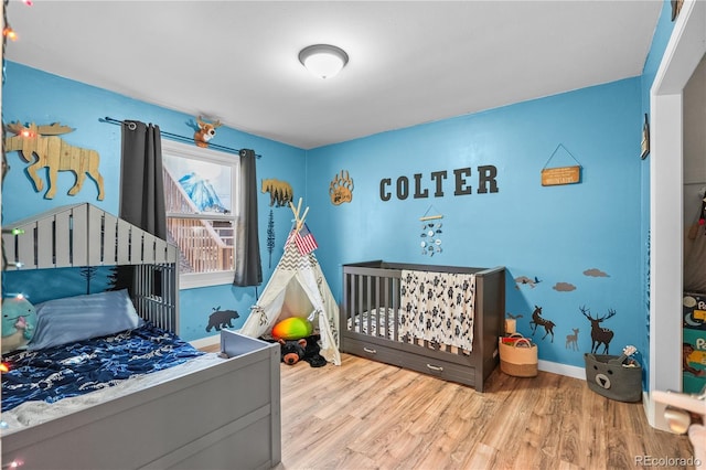 bedroom with wood finished floors and baseboards