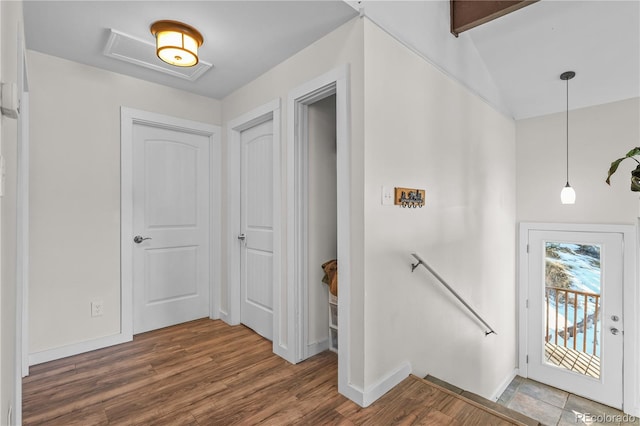 foyer featuring lofted ceiling, wood finished floors, and baseboards