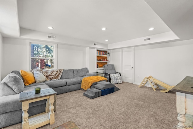 living area with visible vents, recessed lighting, a tray ceiling, and carpet floors