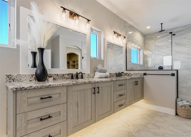 bathroom with vanity, plenty of natural light, and a shower with shower door