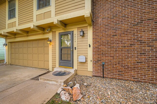 4049 S Nucla Way, Aurora, CO 80013 - view of exterior entry featuring a garage, driveway, and brick siding