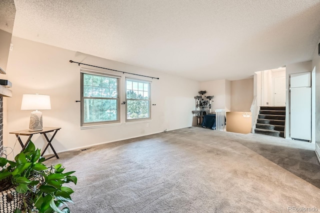 4049 S Nucla Way, Aurora, CO 80013 - unfurnished living room featuring carpet flooring, a textured ceiling, stairs, and a fireplace