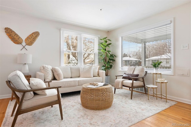 sitting room with plenty of natural light, baseboards, and wood finished floors