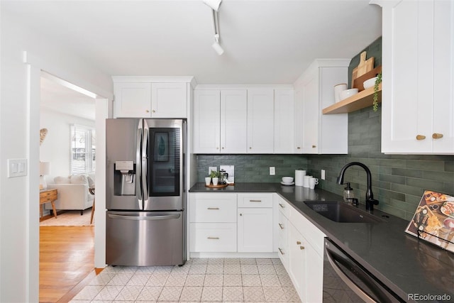 kitchen with a sink, stainless steel fridge with ice dispenser, dishwasher, open shelves, and dark countertops