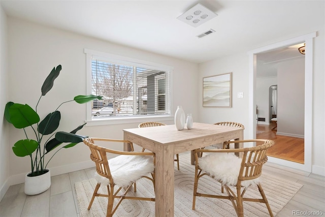 dining room featuring visible vents, light wood-style flooring, and baseboards