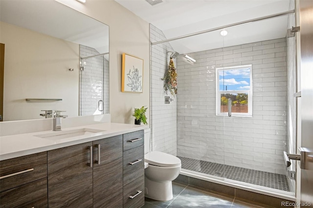 bathroom featuring toilet, vanity, tile patterned floors, and a shower with door