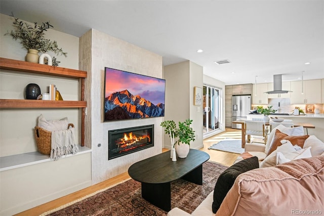 living room with a fireplace and light wood-type flooring