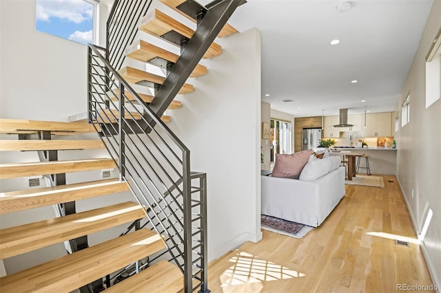 stairs featuring hardwood / wood-style floors and a wealth of natural light