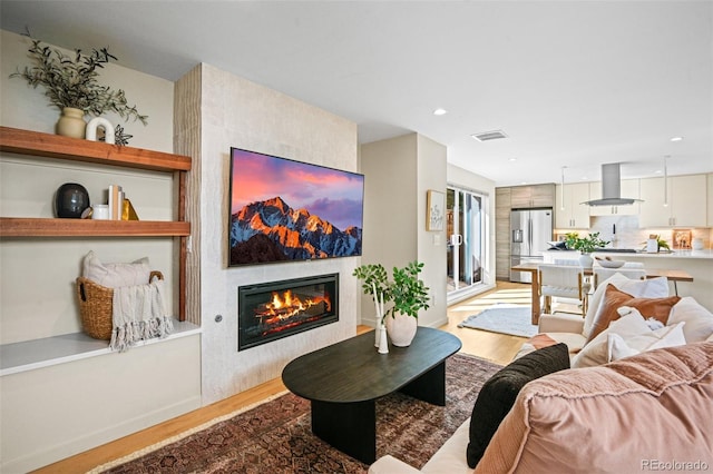 1415 Irving St, Denver, CO 80204 - living area featuring wood finished floors, a glass covered fireplace, recessed lighting, and baseboards
