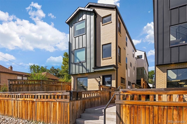 1415 Irving St, Denver, CO 80204 - view of front of house featuring board and batten siding, brick siding, and a wooden deck