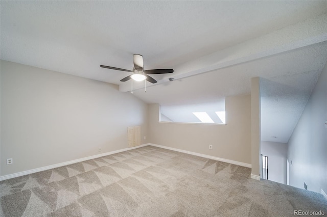 carpeted empty room with vaulted ceiling and ceiling fan