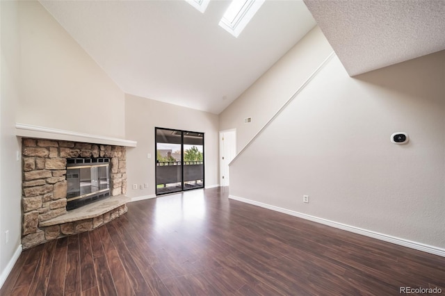 unfurnished living room featuring wood-type flooring, a fireplace, a skylight, and high vaulted ceiling