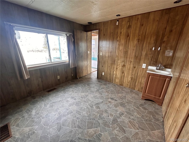 empty room featuring sink and wood walls