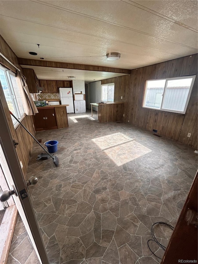 spare room featuring plenty of natural light and wood walls