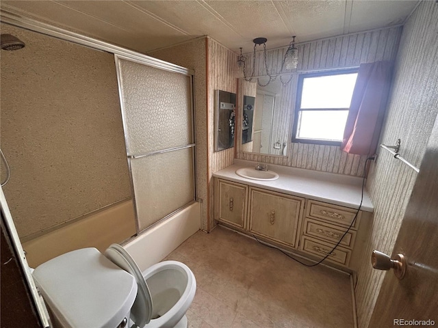 full bathroom with vanity, a textured ceiling, enclosed tub / shower combo, and toilet