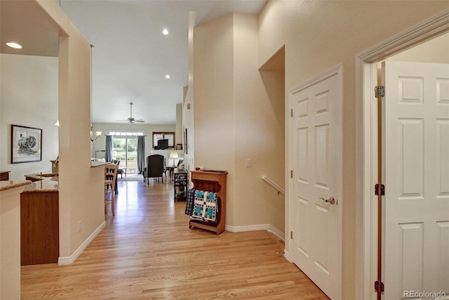 hall featuring recessed lighting, light wood-type flooring, an upstairs landing, and baseboards