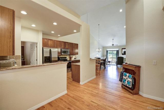 kitchen featuring stainless steel appliances, light wood-style floors, a peninsula, and baseboards