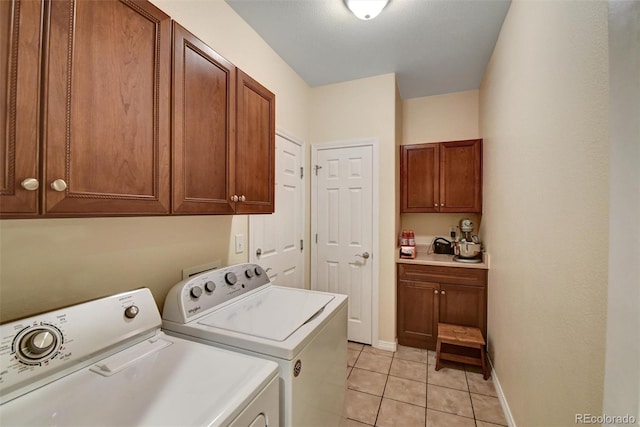 laundry area with cabinet space, light tile patterned floors, baseboards, and separate washer and dryer