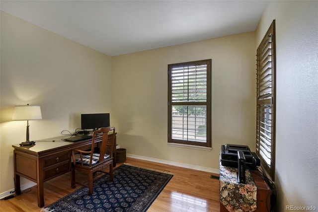 office space with baseboards and wood finished floors