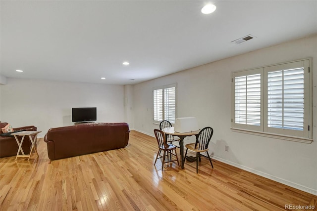 living area featuring light wood-style floors, baseboards, visible vents, and recessed lighting