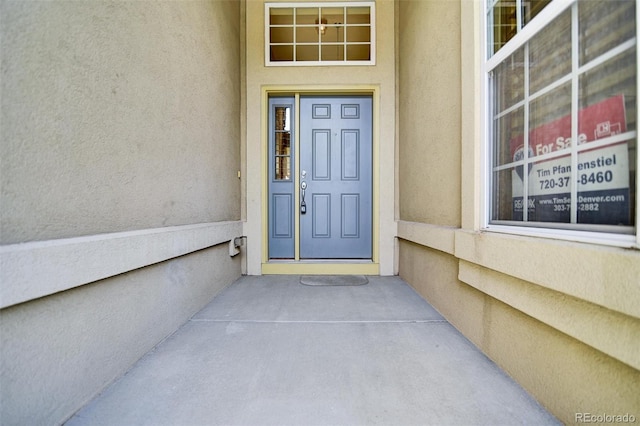 property entrance with stucco siding