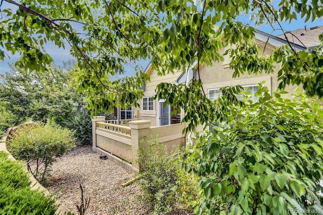 view of side of home featuring a fenced front yard and stucco siding