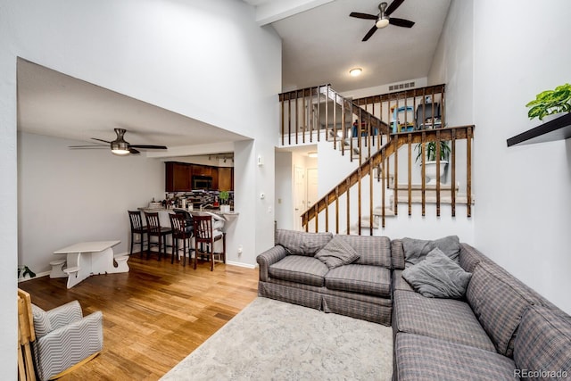4356 S Blackhawk Way, Aurora, CO 80015 - living room featuring a ceiling fan, light wood-type flooring, stairs, and high vaulted ceiling