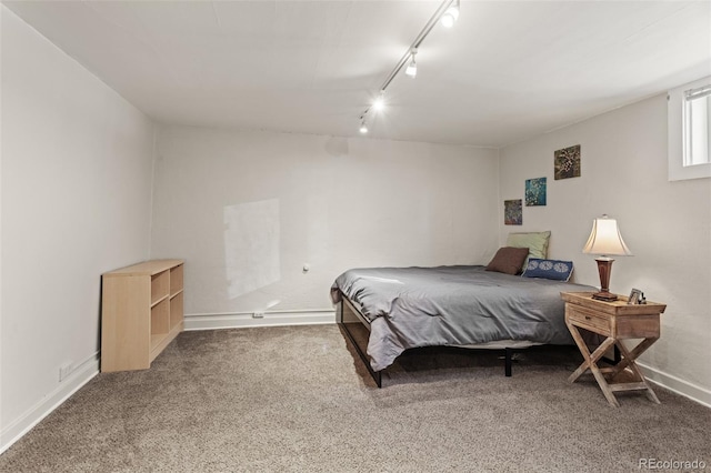 carpeted bedroom featuring rail lighting